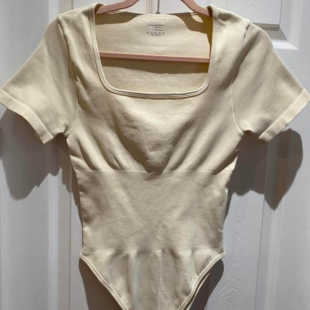 cream bodysuit with square neckline and short sleeves . Size L